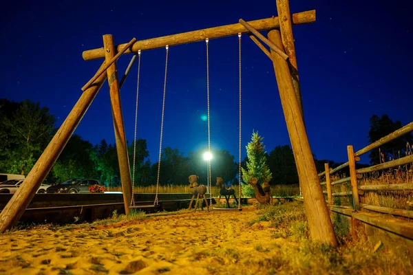 Wooden swing at night in the village.