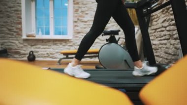 Woman jogging on treadmill at the gym.