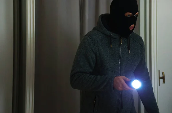 Maskierter Räuber Mit Taschenlampe Kontrolliert Wohnung — Stockfoto