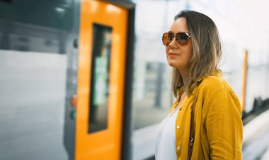 Woman and train passing by at the station.