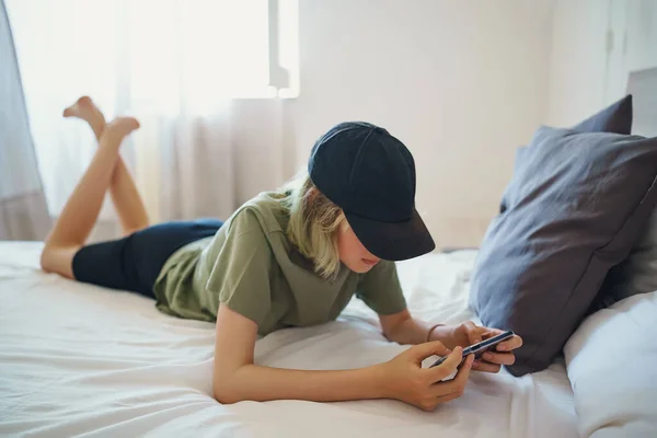 青少年躺在床上 床上挂着智能手机 小玩意上瘾的概念 — 图库照片