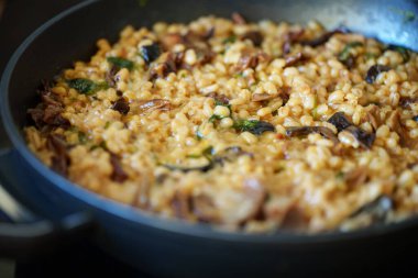 İnci arpalı altın orzotto tavada hazırlanıyor.