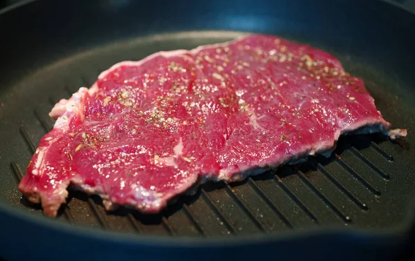血淋淋的牛肉在锅里煎 — 图库照片