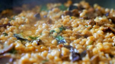 İnci arpalı altın orzotto tavada hazırlanıyor.