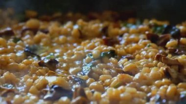 İnci arpalı altın orzotto tavada hazırlanıyor.