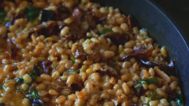 İnci arpalı altın orzotto tavada hazırlanıyor.