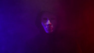 Neon arka planda kapüşonlu maskeli bir adam..