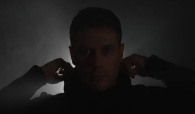 Yakışıklı adam siyah kapüşonlu giyiyor..