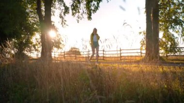 Woman tourist with backpack walking in the countryside.