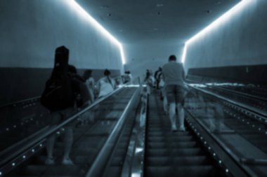 İnsanlar metroda elektrikli yürüyen merdiven kullanıyorlar..