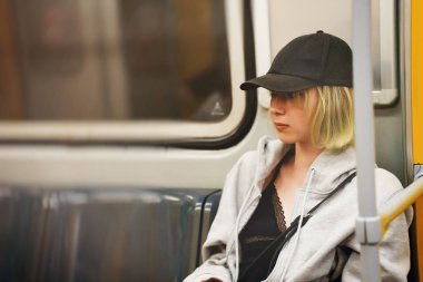 Genç kız metro trenine biniyor..