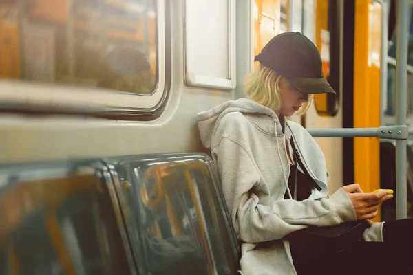 乘坐地铁的带智能手机的少女 — 图库照片