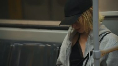 Akıllı telefonları olan genç bir kız metroya biniyor..