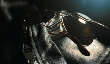 Siyah deri ceket ayrıntıları ve güneş gözlüğü..