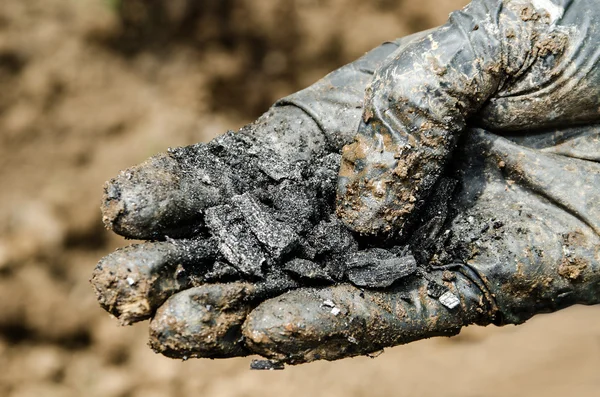 Mano nei guanti con un carbone di legna — Foto Stock