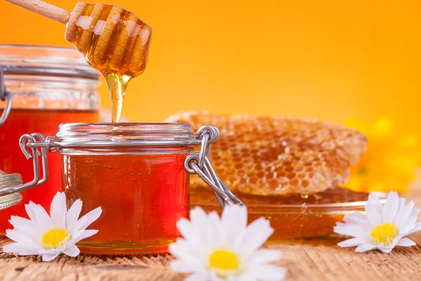 Mel em jarra com favo de mel e drizzler de madeira — Fotografia de Stock