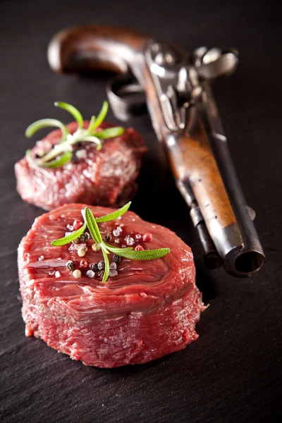 Fresh raw beef steaks on black stone — Stock Photo, Image