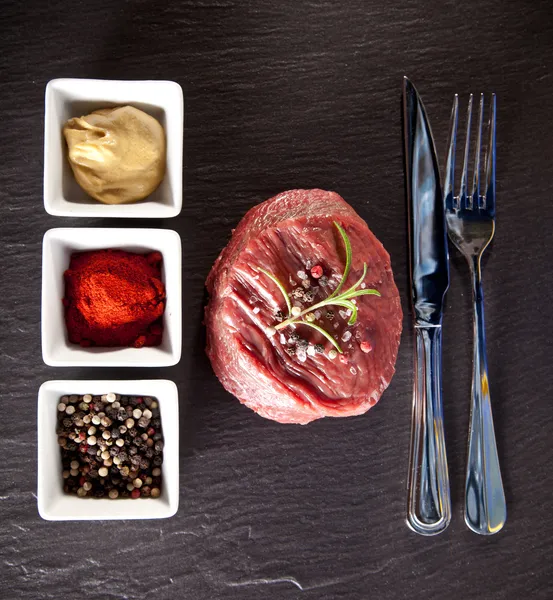 Fresh beef raw steak on black stone — Stock Photo, Image