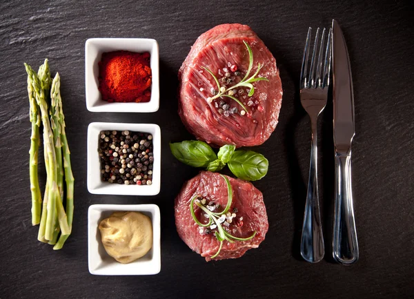 Bifes crus de carne fresca em pedra preta — Fotografia de Stock