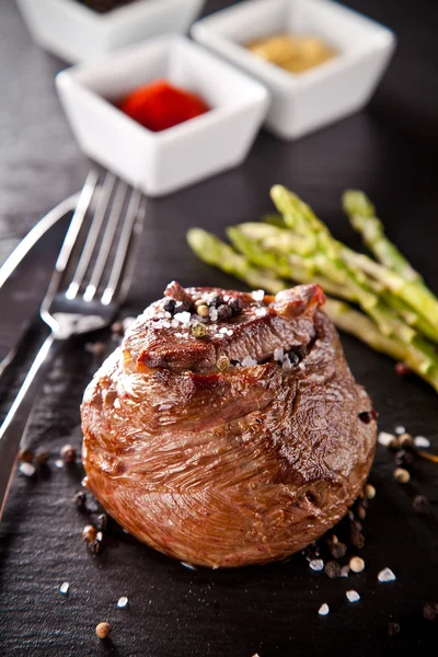 Fresh beef steak on black stone — Stock Photo, Image