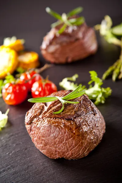 Fresh beef steaks on black stone — Stock Photo, Image