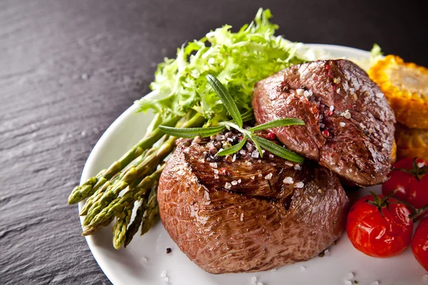 Frisches Rindersteak auf schwarzem Stein — Stockfoto