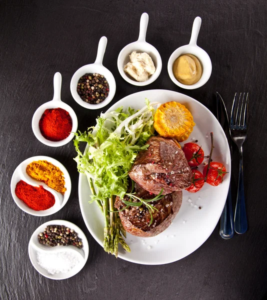 Fresh beef steak on black stone — Stock Photo, Image