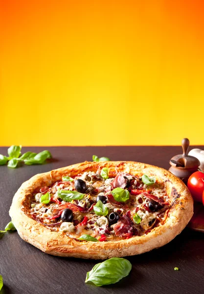 Färsk italiensk pizza serveras på svart sten — Stockfoto