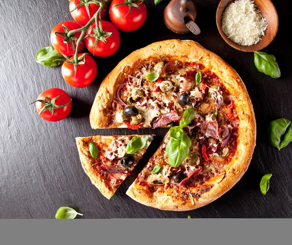 Fresh italian pizza served on black stone — Stock Photo, Image