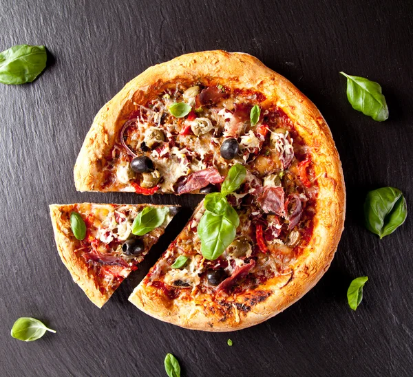 Świeżej pizzy włoskiej serwowane na czarny kamień — Zdjęcie stockowe