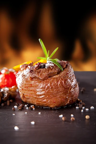 Bife de carne fresca em pedra preta e fogo — Fotografia de Stock