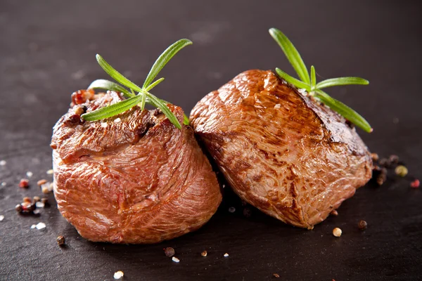 Čerstvé hovězí steaky na černém kameni — Stock fotografie