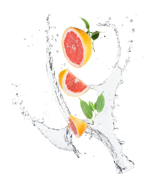 Stukken van grapefruit in water splash — Stockfoto