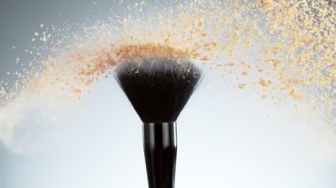Patlayan bej tozuyla çok yavaş makyaj fırçası. Yüksek hızlı sinema kamerası, 1000fps.