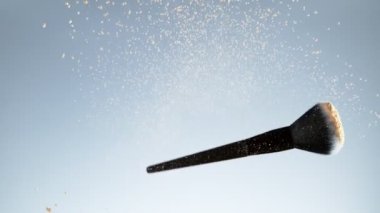 Makyaj fırçasını bej tozuyla döndürmek için süper yavaş çekim. Yüksek hızlı sinema kamerası, 1000fps.