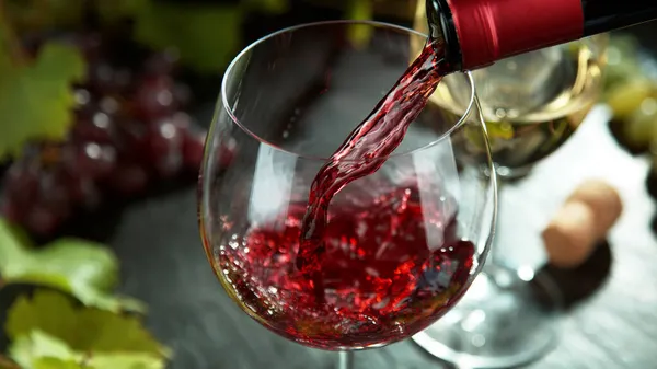 Makroaufnahme Des Einfüllens Von Rotwein Glas Stillleben Mit Weintrauben Auf — Stockfoto