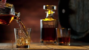 Buz küpünün viski içkisine düşmesi çok yavaş bir hareket. Yüksek hızlı sinema kamerası, 1000 fps. Hız rampası etkisi.