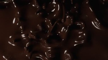 Süzülen siyah çikolatanın süper yavaş akışı. Yüksek hızlı sinema kamerası, 1000fps.