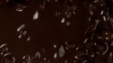 Süzülen siyah çikolatanın süper yavaş akışı. Yüksek hızlı sinema kamerası, 1000fps.