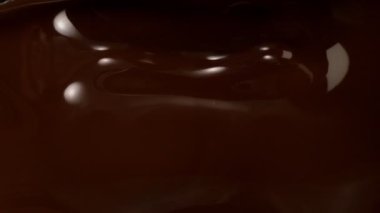 Süzülen siyah çikolatanın süper yavaş akışı. Yüksek hızlı sinema kamerası, 1000fps.