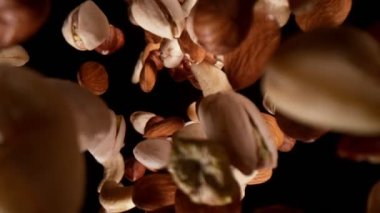 Düşen fındıkların süper yavaş çekimi, geniş süper makro çekim. Siyah arka planda izole edilmiş. Yüksek hızlı sinema kamerası, 1000fps.