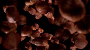 Düşen fındıkların süper yavaş çekimi, geniş süper makro çekim. Siyah arka planda izole edilmiş. Yüksek hızlı sinema kamerası, 1000fps.