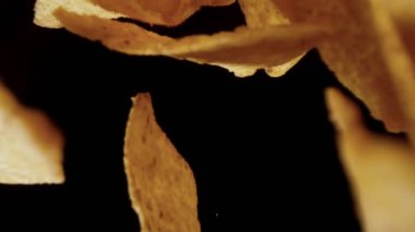 Siyah arka plan üzerinde uçan tortilla cips süper yavaş hareket. Yüksek hızlı sinema kamera, 1000 fps filme.