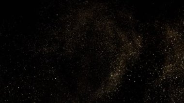 Siyah zemin üzerinde ışıldayan altın parçacıkların süper yavaş çekimi. Sığ odak derinliği. Yüksek hızlı sinema kamerası, 1000 fps..