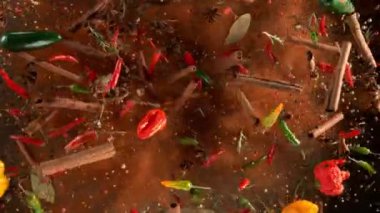 Uçan baharatların süper yavaş çekimi siyah arka planda karışır. Hız rampası etkisi. Yüksek hızlı sinema kamerası, 1000 fps.