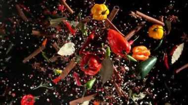 Uçan baharatların süper yavaş çekimi siyah arka planda karışır. Hız rampası etkisi. Yüksek hızlı sinema kamerası, 1000 fps.