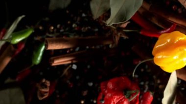 Uçan baharatların süper yavaş çekimi siyah arka planda karışır. Yüksek hızlı sinema kamerası, 1000 fps.