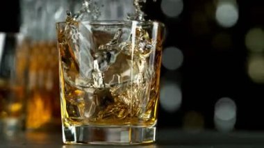 Buz küpünün viski içkisine dönüşmesi çok yavaş bir hareket, kamera hareketi. Hız rampası etkisi. Yüksek hızlı sinema kamerası, 1000 fps..