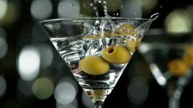 Zeytinlerin kokteyl içeceğine düşmesi, kamera hareketi. Yüksek hızlı sinema kamerası, 1000 fps..