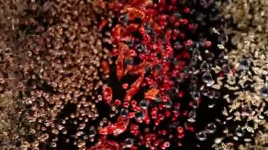 Uçan baharatların süper yavaş çekimi siyah arka planda karışır. Hız rampası etkisi. Yüksek hızlı sinema kamerası, 1000 fps..